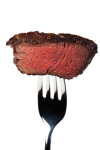 piece of a grilled steak on a fork